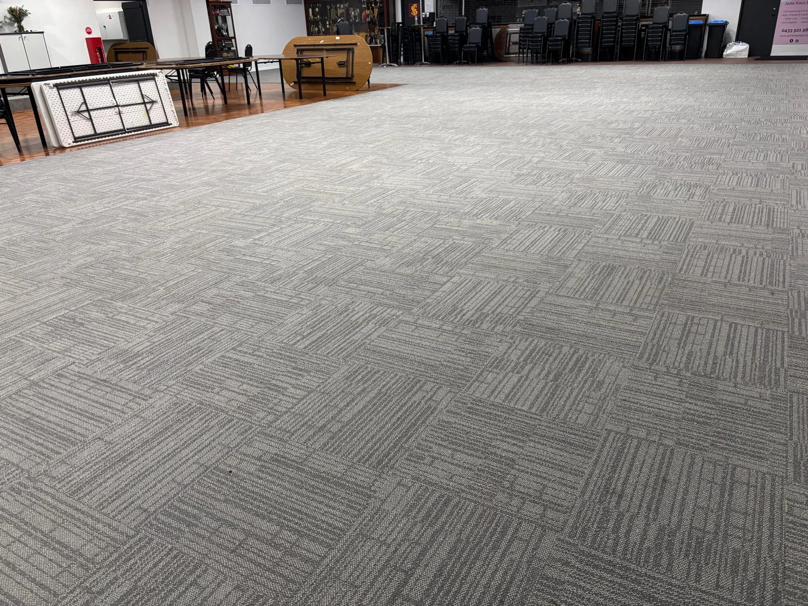 Freshly cleaned grey carpet tiles in a large community hall